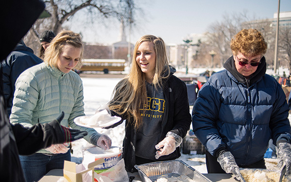 Student and faculty handing out food to people in need