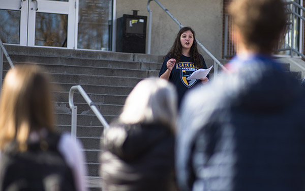 girl addressing a crowd on the library steps