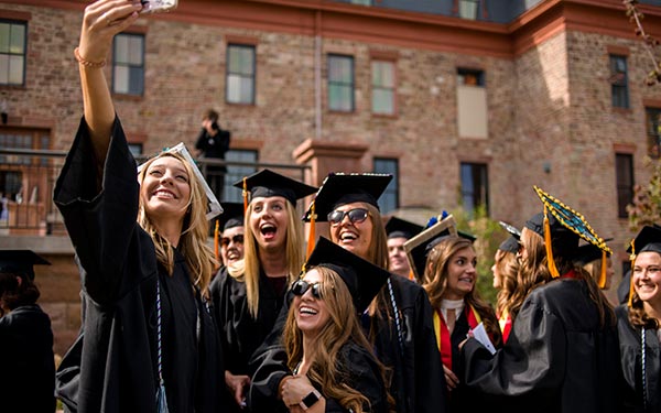 graduates take selfie at commencement