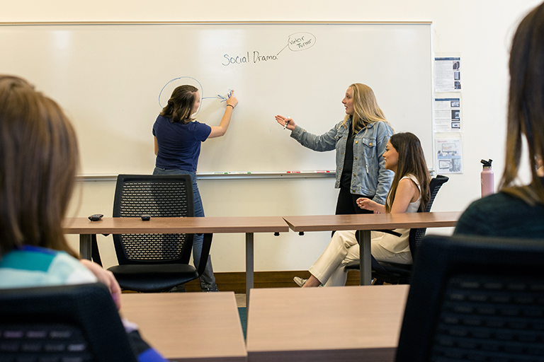 two students debate in a Regis classroom