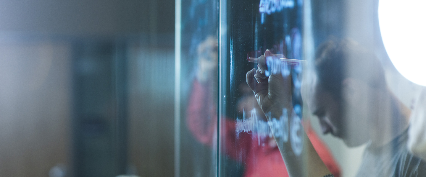 student writing on glass window