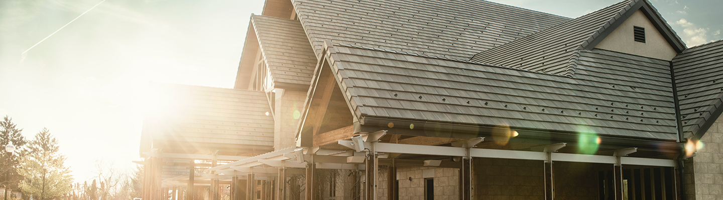 Exterior of St. Regis Chapel with sunlight coming in from the left and the building taking up the right