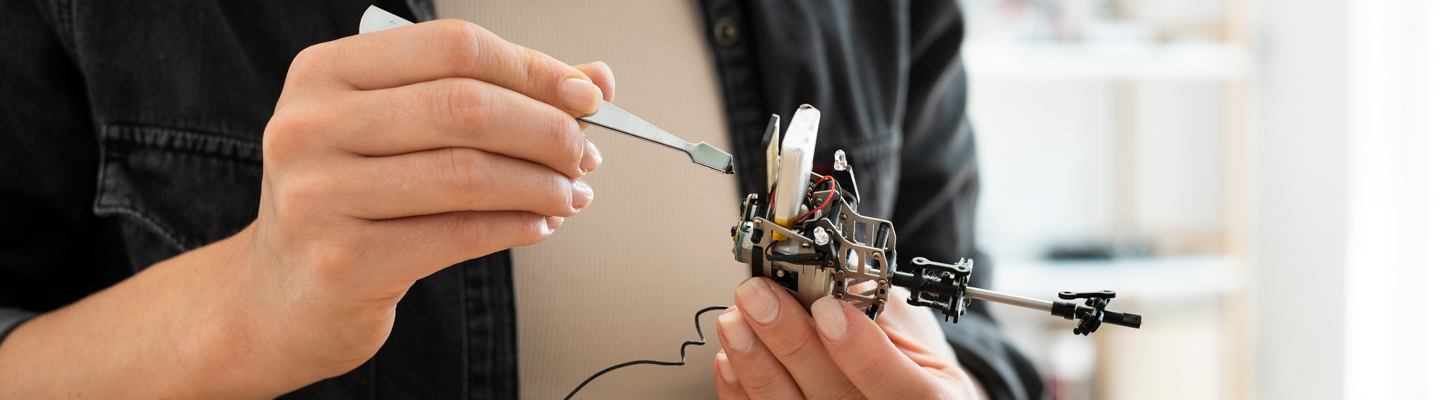 student assembling a robotics or drone device in a lab setting
