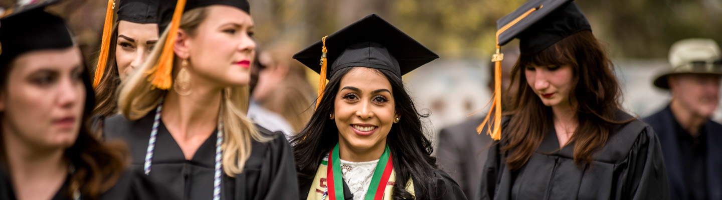 happy graduate walks at commencement