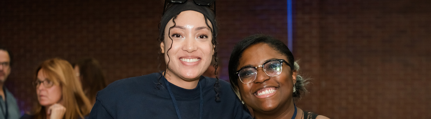 two alumni standing together with big, bright smiles at the Iggy Beer Fest