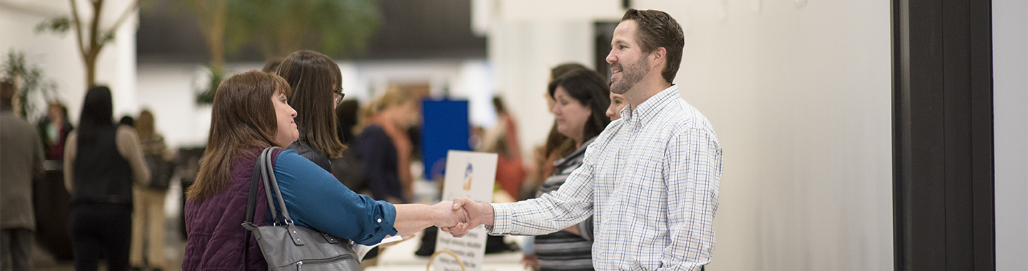 Man and woman shake hands at an internship fair