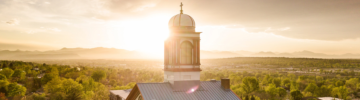 sunset behind the cupola of Main Hall on the northwest Denver campus
