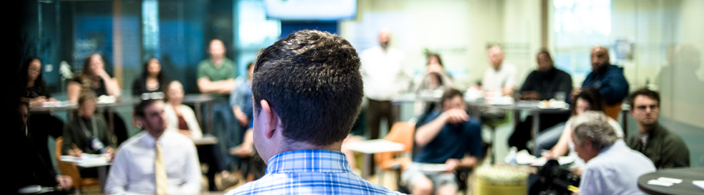 man speaks in front of crowd