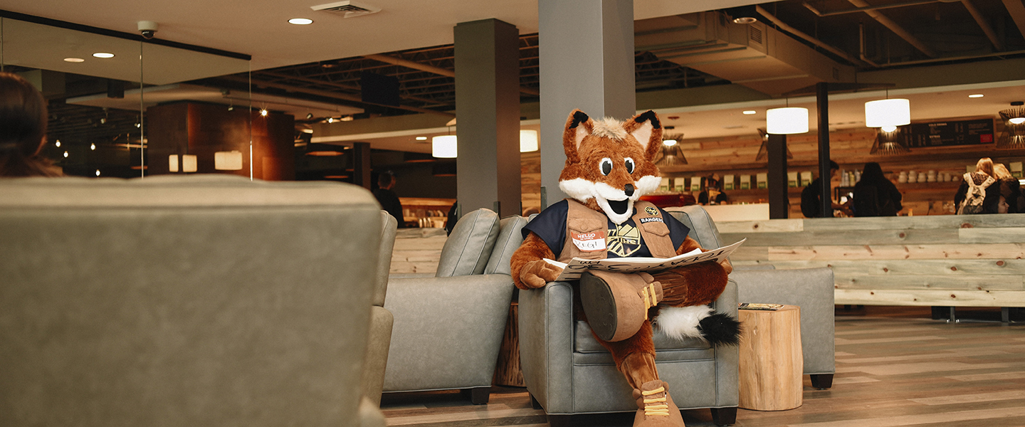 regi sitting in student center reading