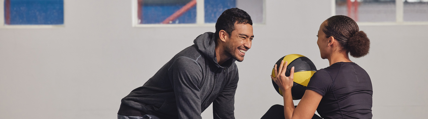 A person receiving physiotherapy on their knee, wearing a brace, while another person is assisting