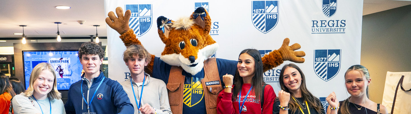 a group of first-year students pose with Regis the mascot in the Student Center on the Regis Denver Campus