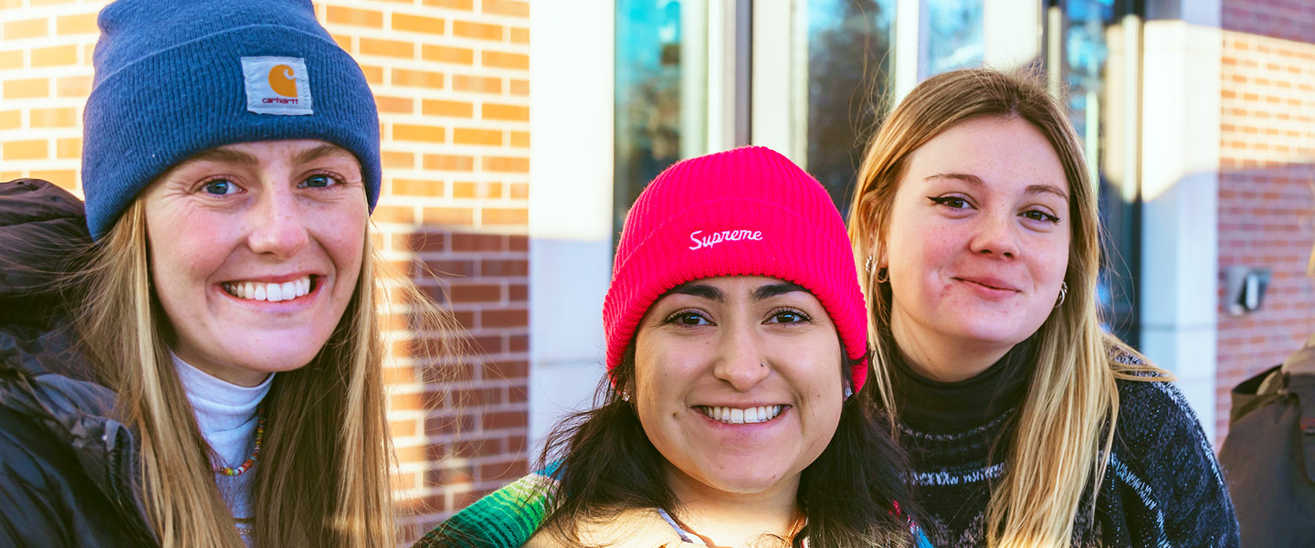 three friends pose for a photo outdoors during SnowJam on the Northwest Denver Campus