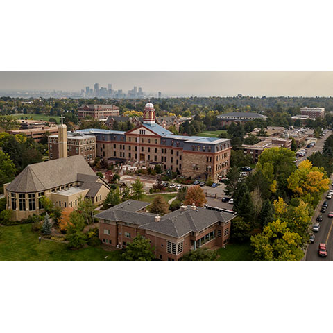 large aerial view of Regis University's campus with the Denver skyline in the background