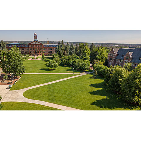 a view of main hall and Carroll Hall across the quad on a sunny summer day
