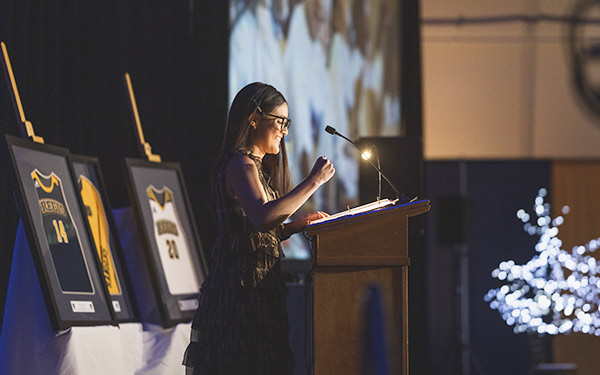 student stands behind a podium while speaking at the University's Donor Dinner