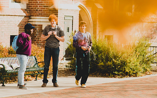 3 students near carroll hall