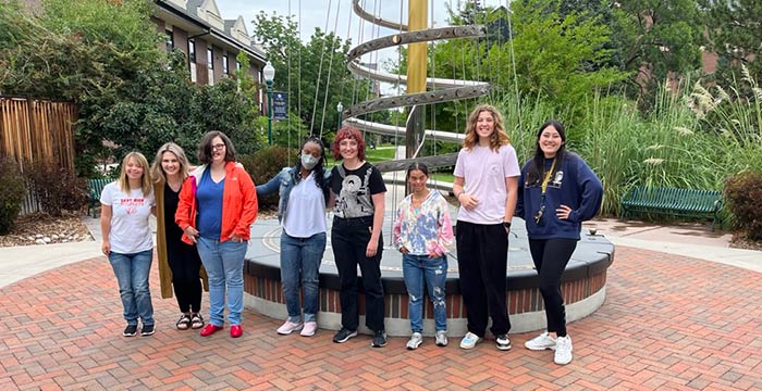 GLOBAL students posing at tree of life on campus