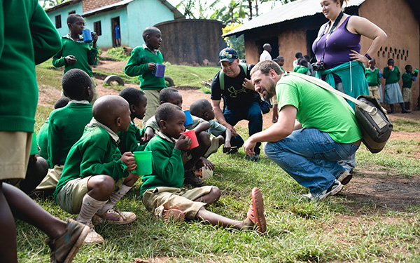 student speaking with group of children