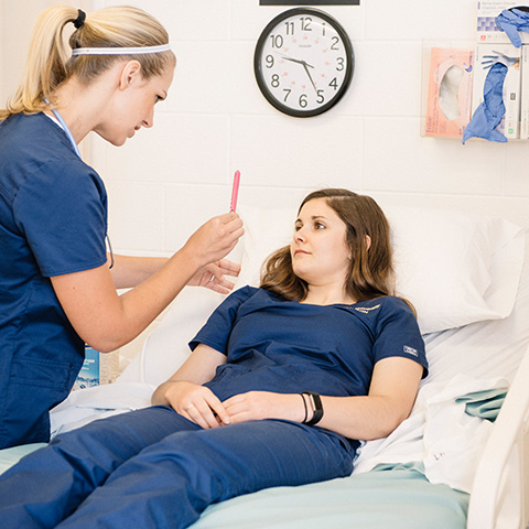 Nurse checking woman's eyes