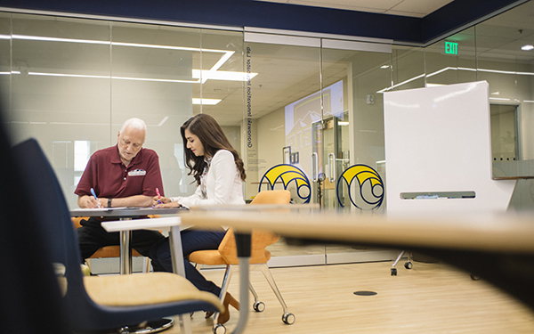 student and tutor work at a table in classroom