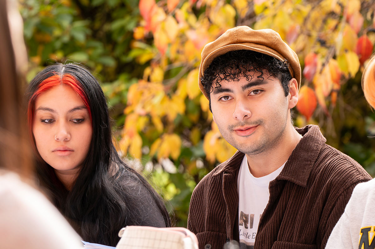 Adan sits with his classmates during an outdoor class on the Regis campus in Denver, Colorado