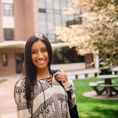 student smiling holding backpack