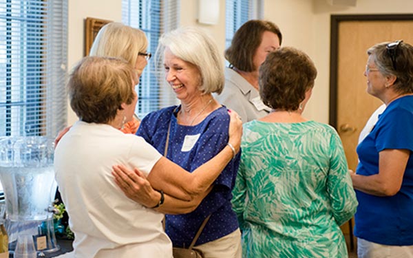 Alumni embrace one another at alumni event