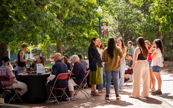 People gathering outdoors at a Regis University community event.