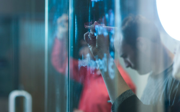 business students writing on glass wall