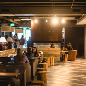 Students relax in Regi’s Roasts under warm lighting.