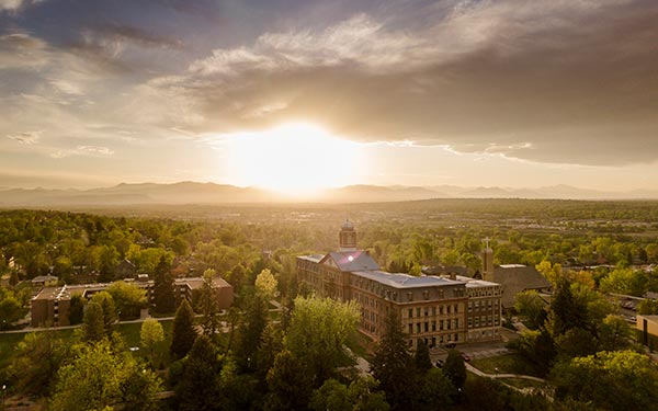 an aerial view of the Regis campus at sunset with the Rocky Mountains in the background