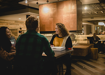 students sitting and socializing at a table in Walker's Pub