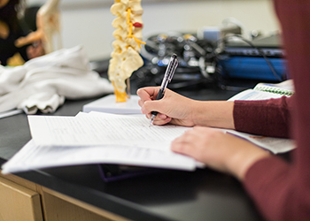 student taking notes in science classroom