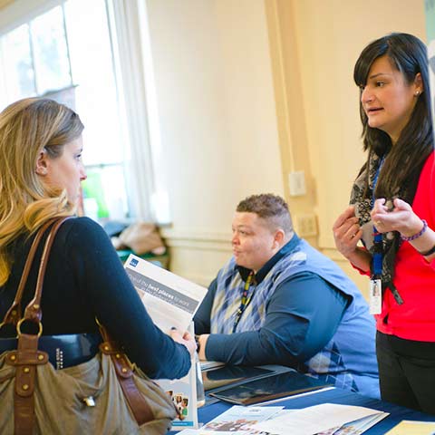 a staff member talks with a student at a career fair in Main Hall on the Northwest Denver campus