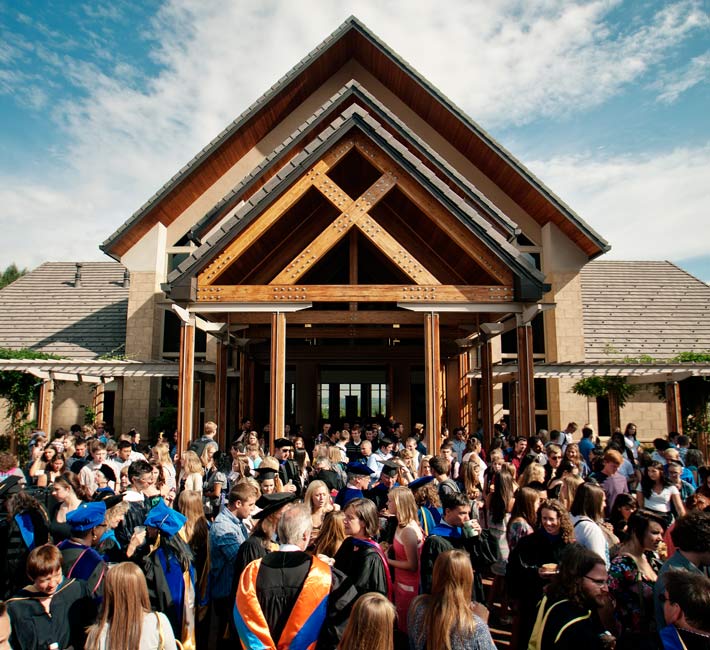 Regis University graduates and guests gathered outside the campus chapel following commencement.