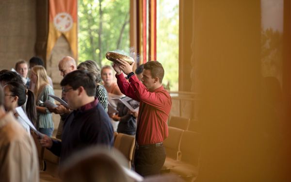 Student participating in a Catholic liturgy as part of campus faith life.