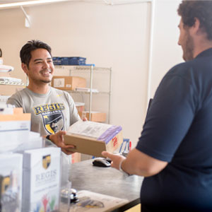 student hands package to worker