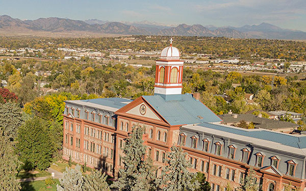 Aerial picture of main hall with Denver suburbs in the background along with the mountains
