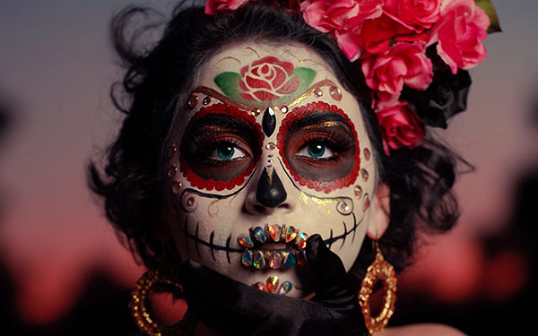 Woman looking straight into camera with dia de los muertos makeup