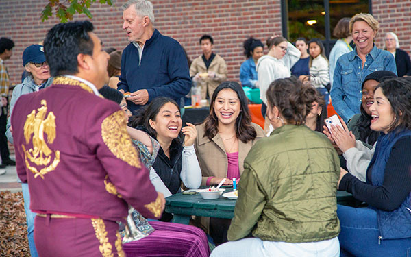 students and campus visitors enjoy food and mariachi music outside the Student Center on the Regis campus