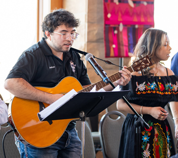 Students singing and playing guitar during a live campus performance