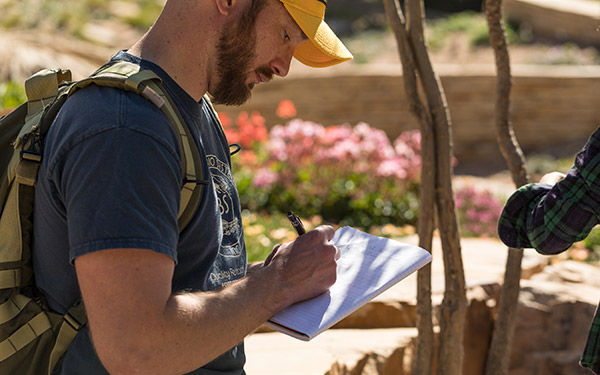 Student making notes at botanic garden