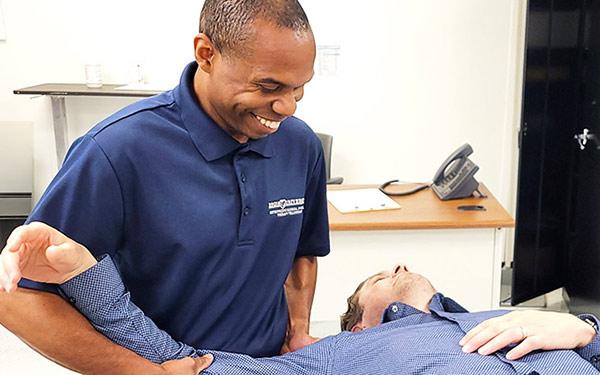 A Regis Physical Therapy Fellowship student works with a client in a classroom on the Denver, Colorado campus