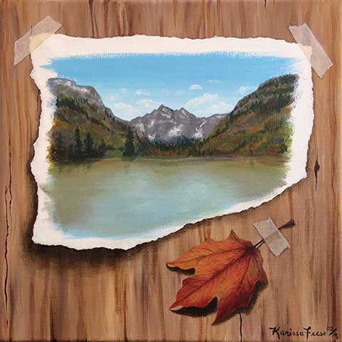 painting of a landscape on a scrap of paper taped to a wooden surface beside a taped leaf