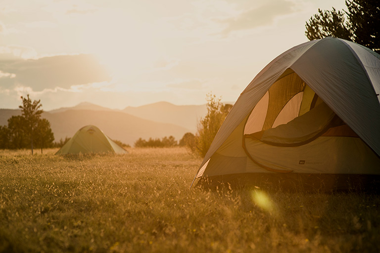Camping scene with tent at sunset