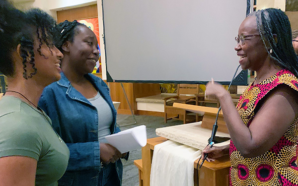 Author Farrah Jasmine Griffen chats with two students after her talk in the Regis Chapel