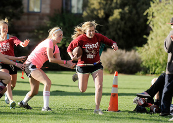 women play flag football outdoors