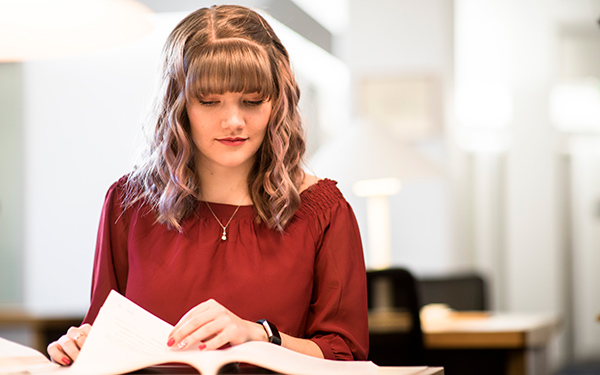 girl studies book in library