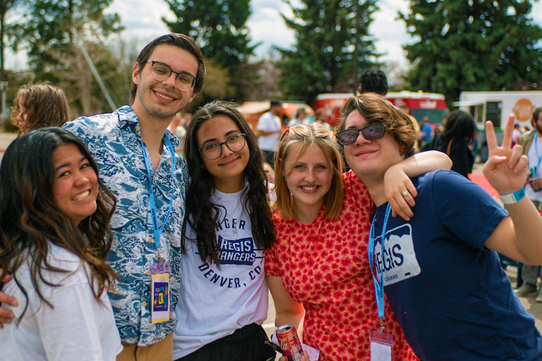 Students hug and pose for photo outdoors