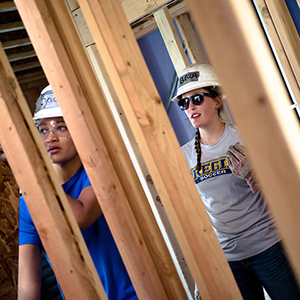 student building a house wearing regis tshirt